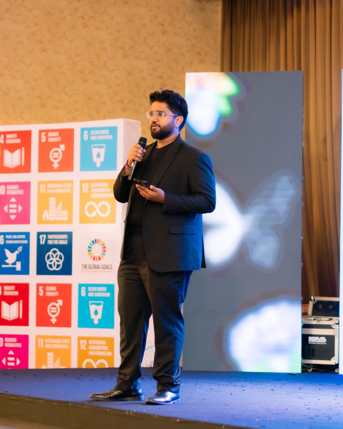 Arfan Nazar, founder of Alchemi, speaking on stage